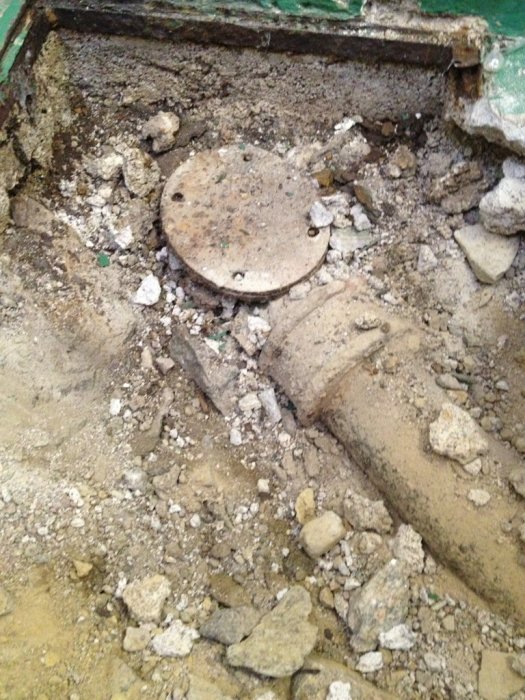 Pipe connection in concrete rubble, possibly a joint.