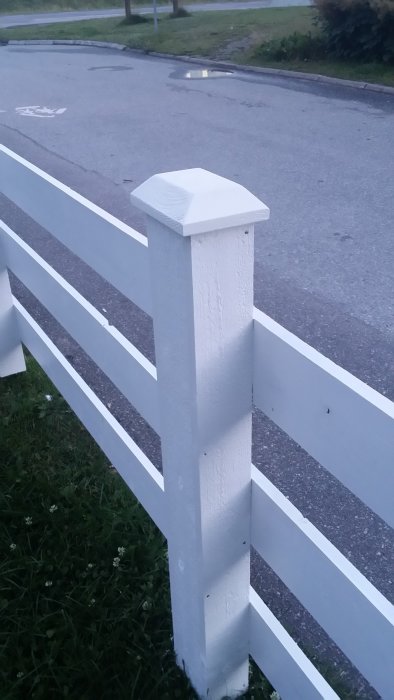 White wooden fence by a roadside, highlighting construction joints possibly discussing adhesive efficiency.