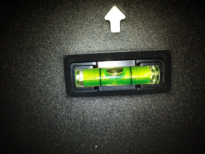 Et vaterpas viser en boble uden for center på en sort baggrund, hvilket indikerer, at objektet er skævt.