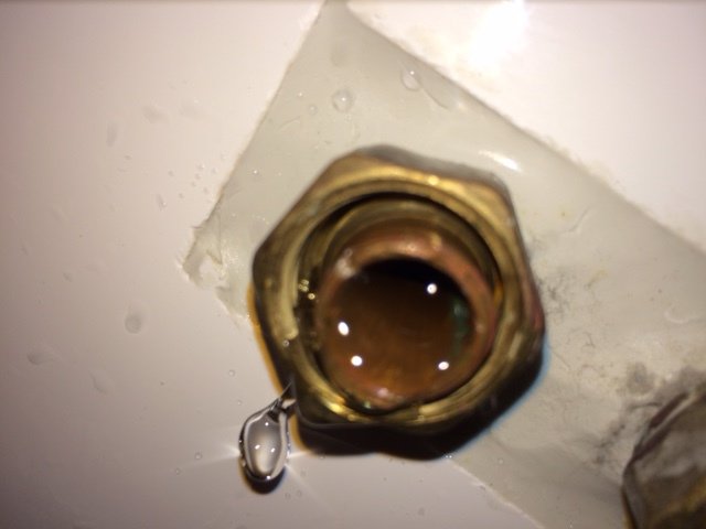 Närbild på en demonterad kopparrörskoppling i en vägg som är redo för installation av ett badkar.