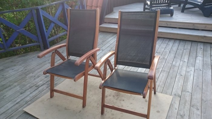 Två renoverade trästolar på altan, varav en är nyslipad och grundmålad och den andra är inoljad.