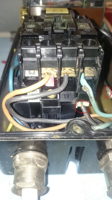 Elskåpet öppet med en blå kabel och svart hölje lossnat, nära en annan svart lös kabel, tecken på brännskador synliga.