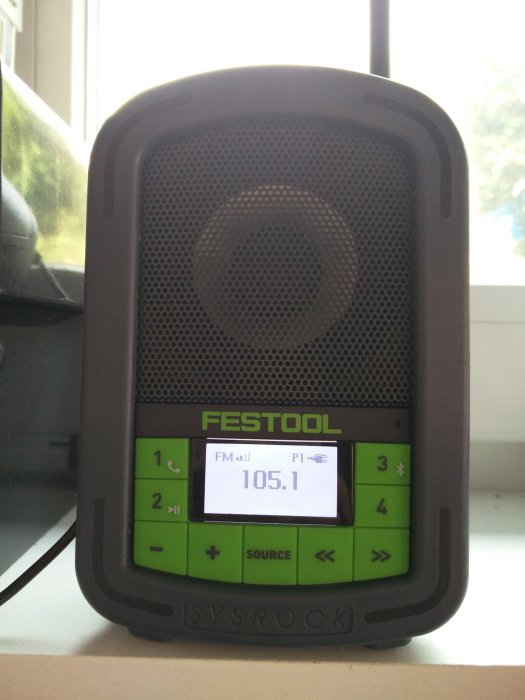 Festool Sysrock arbetsradio på ett fönsterbräde inställd på FM 105.1.