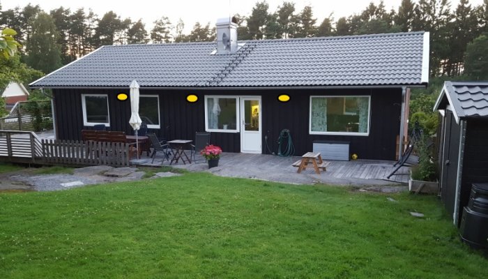 Enhusfasad med gula ringar som markerar föreslagna platser för ytterbelysning.