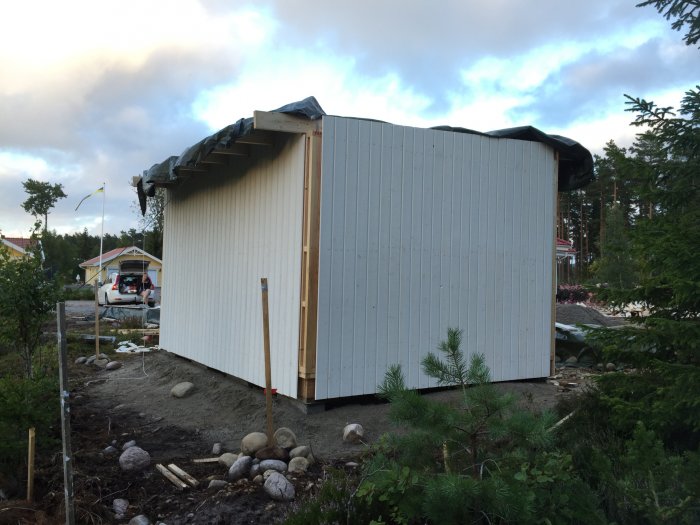 Hörn av hus med falsad spårpanel där spåren inte matchar med knutbrädorna.