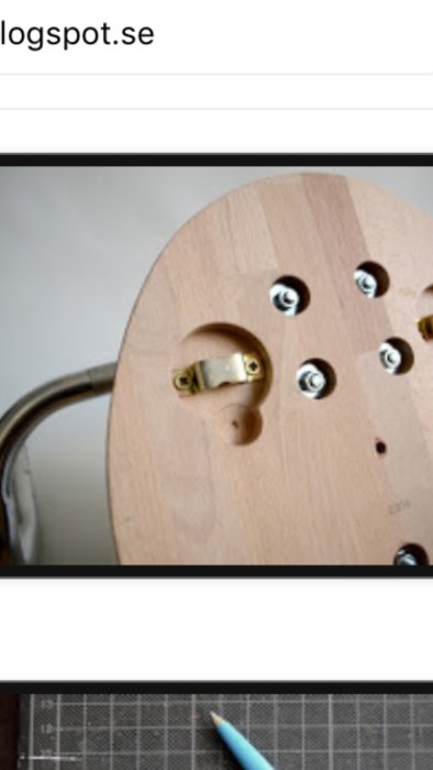 Närbild av en gitarrens inre med en guldig metallkomponent och monteringsbultar.