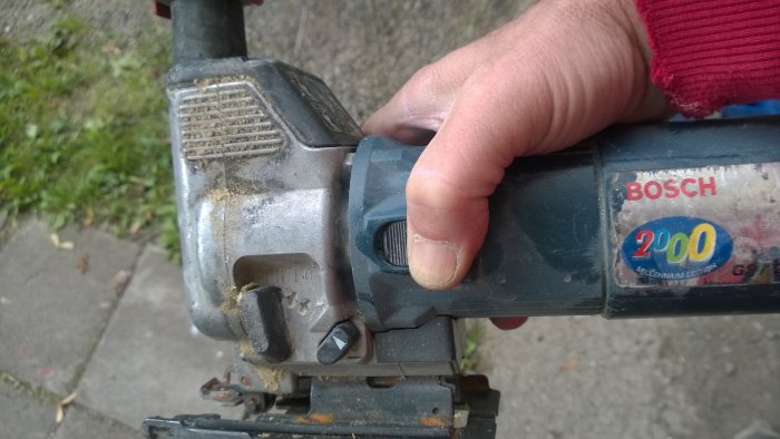 Hand håller en Bosch borr med tummen på avtryckarknappen, indikerar ergonomi för högerhänta.