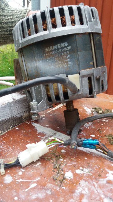 Siemens motor och kabel med avklippt Schuko-kontakt på en träyta med sågspån.