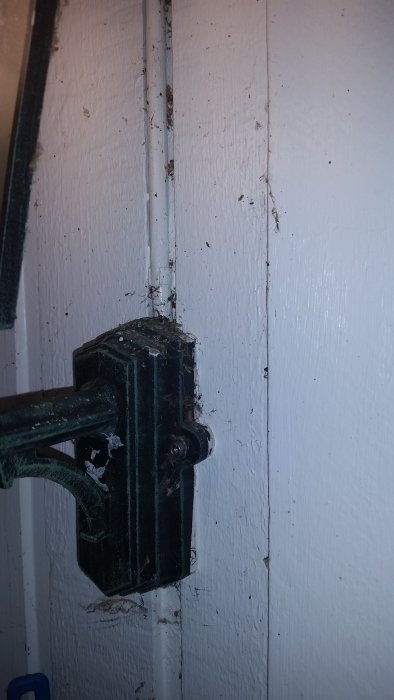 Ojordat vägguttag och ledningar till en utomhuslampa på en vitmålad vägg.