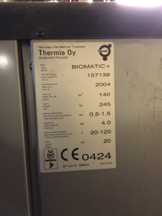 Informationsdekal på en Thermia Biomatic+ panna som visar modellnamn, serienummer och tekniska specifikationer.