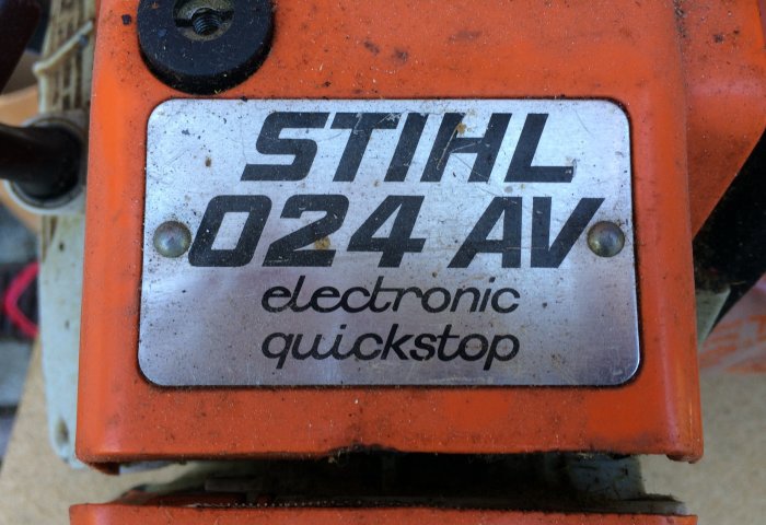 Närbild på en STIHL 024 AV motorsågs emblem med texten "electronic quickstop".