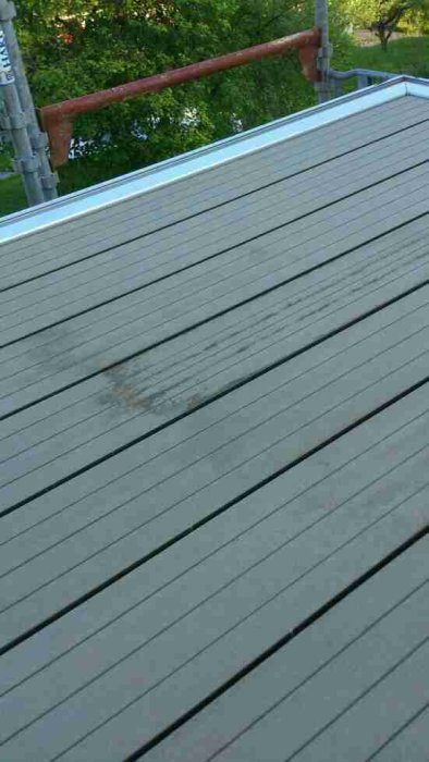 Repkänsligt grått balkonggolv med synlig repa och vattenringar som uppstått över tid.