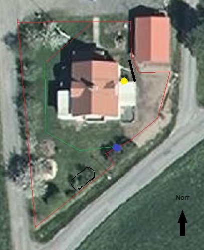 Satellitbild över trädgård markerad med planerad placering för robotgräsklippares laddstation och begränsningskabel.