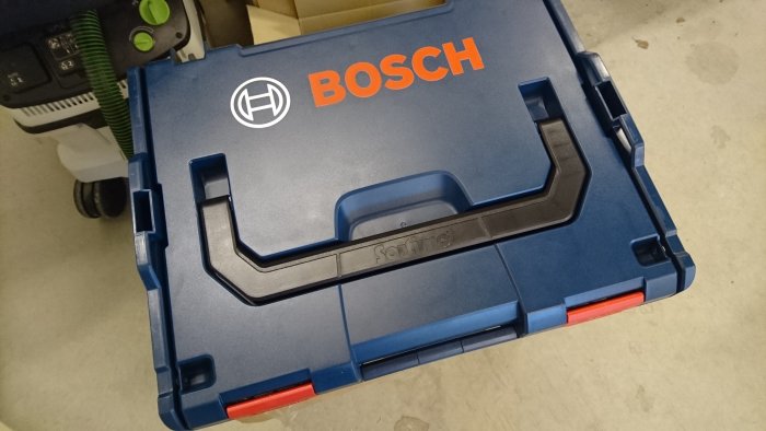 Bosch L-Boxx verktygslåda bredvid en sänksåg för att visa storleksjämförelse.