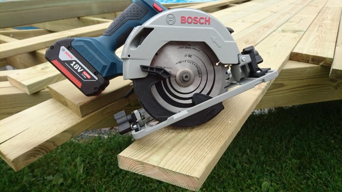 Bosch 18V sänksåg i aktion kapar en trallbräda på träkonstruktion.