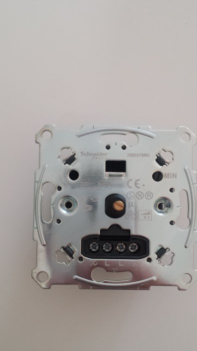 En baksida av en Schneider Electric dimmer med anslutningsterminaler.