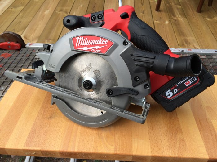 Milwaukee M18 bränsle cirkelsåg på ett träbord.