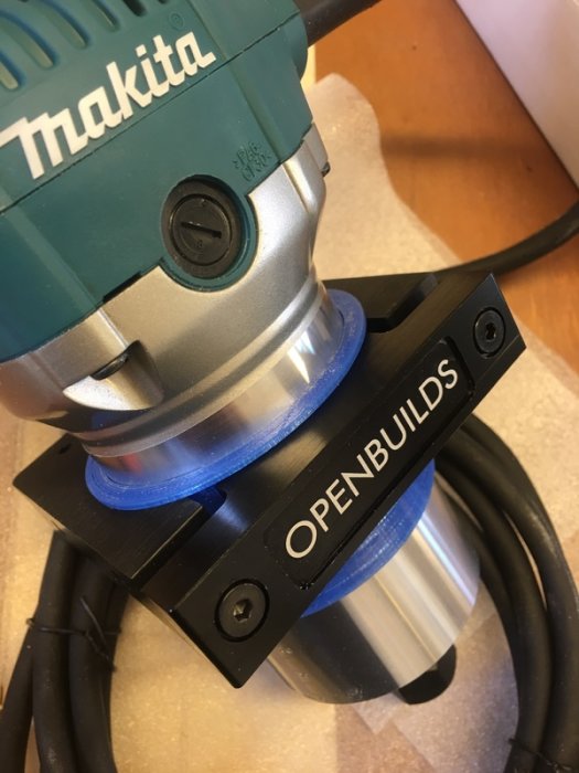 Makita fräsmotor med en tillverkad blå shim installerad i ett svart OPENBUILDS CNC-fäste.