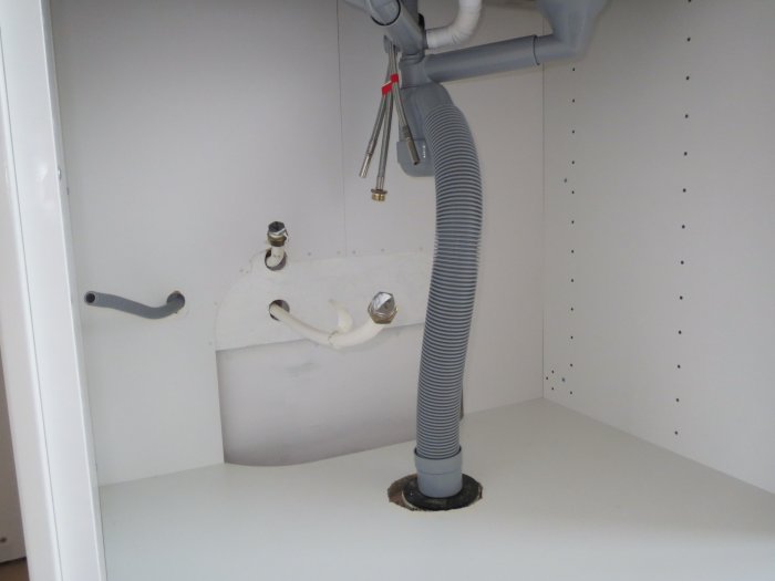 Vattenrör och slangar under köksskåp inför installation av Mora Cera köksblandare.