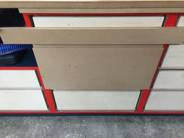 Delvis sågad skivfronter med 7mm glipa för fingergrepp monterade på en verkstadsbänk.