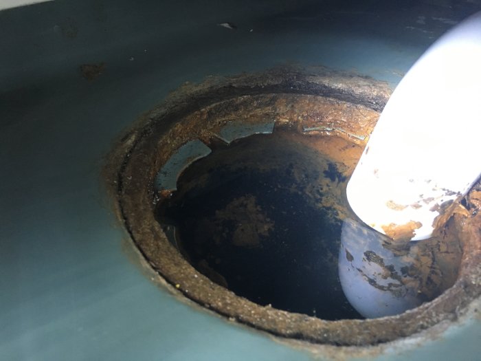 Gammal gjutjärnsbrunn med hög vattennivå och synlig korrosion, behöver renovering.