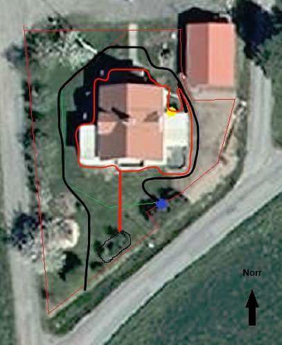 Satellitbild över en fastighet med markerade linjer för planerad robotgräsklipparslinga och laddstation.
