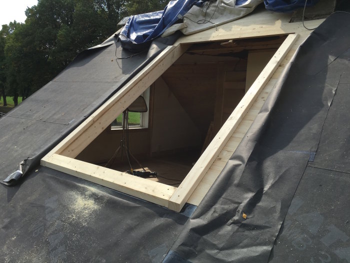 Nyinstallation av takkupa på hus under renovering med synligt takunderlag och träreglar.