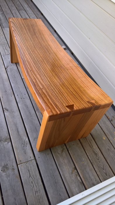 Handgjord bänk av böjd alm planka med Danish Oil finish på träaltan.