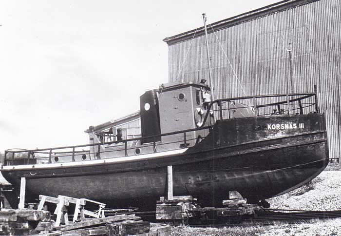 Svartvitt foto av timmerdragaren "KORSNÄS III" från 1926 på land, ombyggd till ateljé.