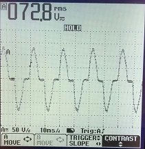 Oscilloskop skärm som visar vågformen av en mätning med en spänning på 72,8 volt rms.