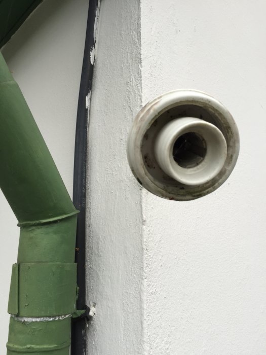 Utebelysning på 20-talshus saknar metallinsats i lampsockeln, närbild på en vit tom lampfot vid ett hörn.