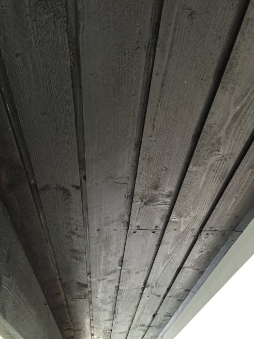 Undertak av träpanel som uppvisar tecken på röta från ett hus byggt 1974.