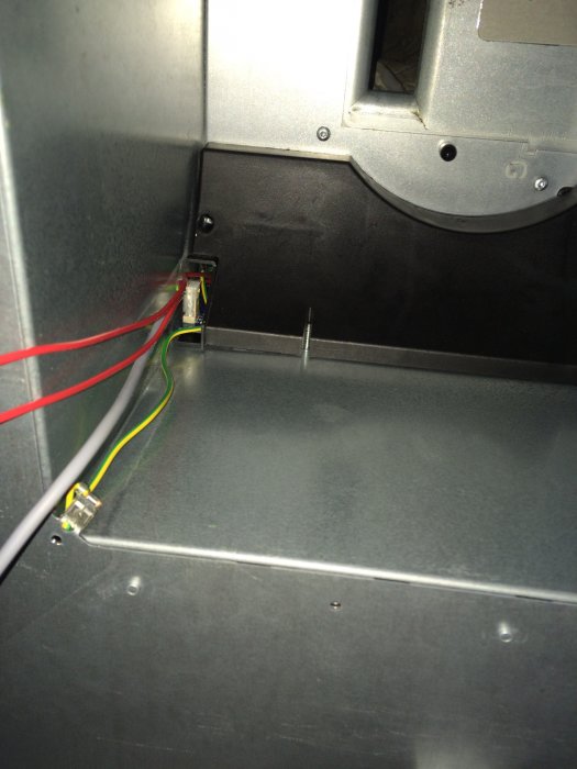 Interiör av en apparat med exponerade trådar och elektroniska komponenter.