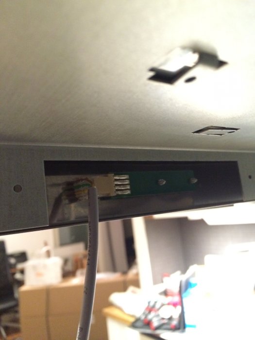 En svart elektronikbox som har tagits loss och visar sig bakifrån med synliga anslutna kablar.