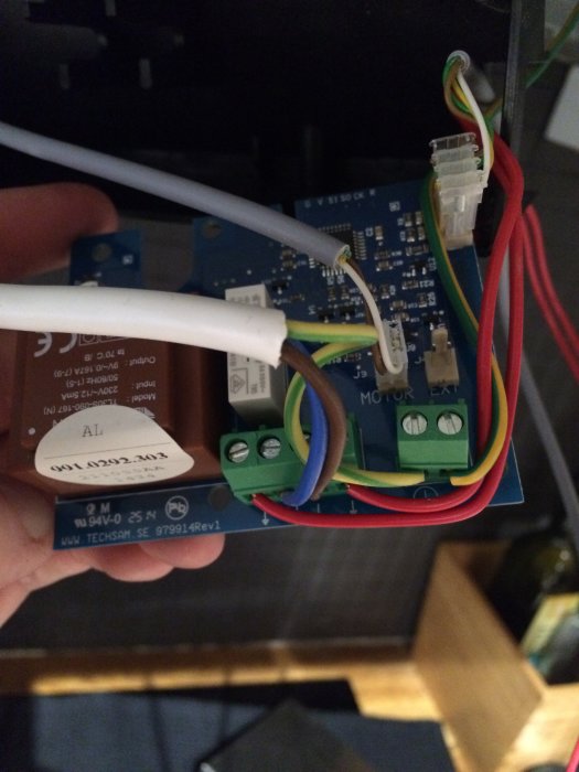 Närgränsad översikt av öppet elektriskt kapslingschassi med elexponerad kretskort och kopplingsdetaljer.