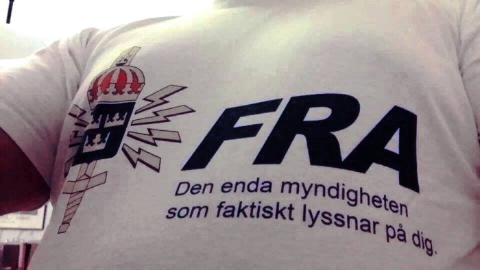 Vit T-shirt med tryck av en antenntorn, blixtrar och texten "FRA Den enda myndigheten som faktiskt lyssnar på dig.