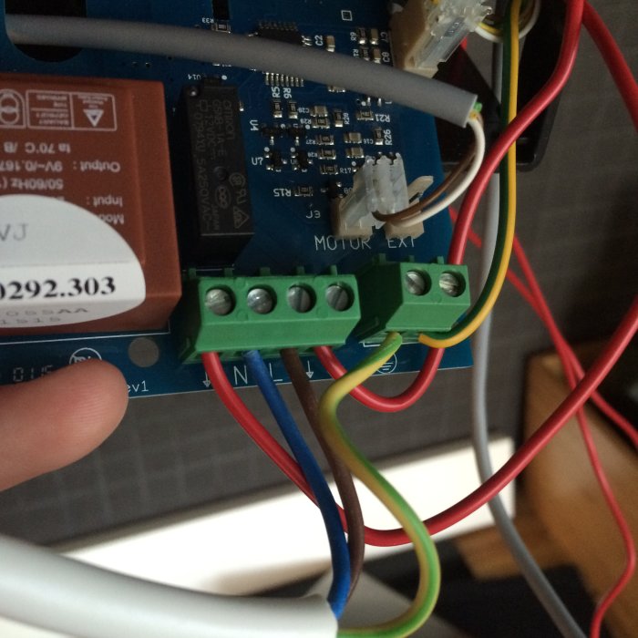 Elektriska anslutningar på ett kretskort med färgkodade kablar och terminalblock redo för strömanslutning.
