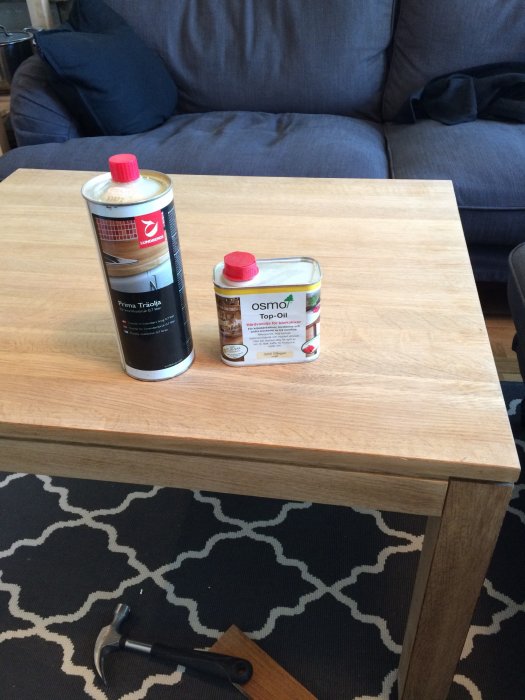 Obehandlat ekbord med träolja och hårdvaxolja ovanpå, hammare vid bordets kant.