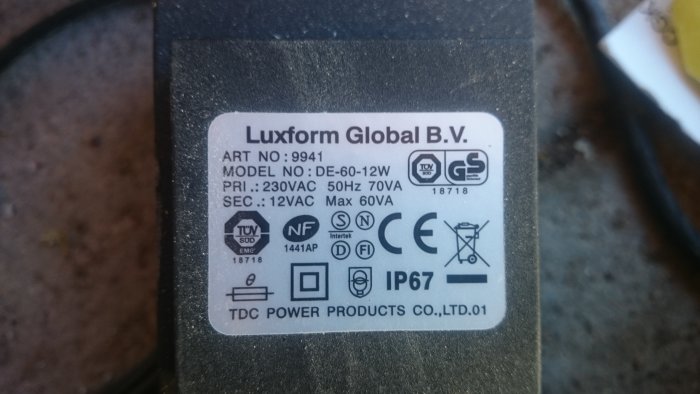 Transformator med specifikationsetikett som visar "Luxform Global B.V.", modellnummer och spänning.