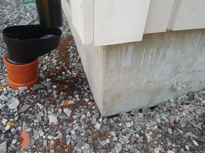 Erosionsskador vid garagegrund där vatten från en felriktad stupränna har tvättat bort material under betongplattan.