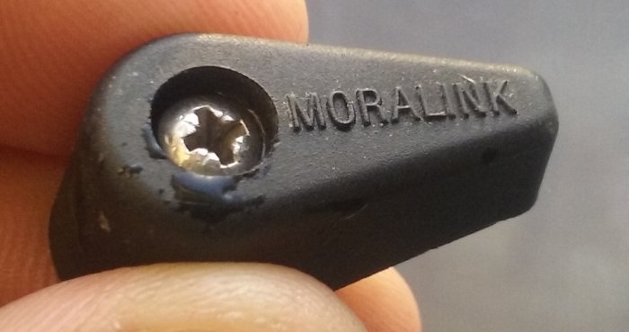 Närbild på en svart Mora Link-kabelsko hållen mellan fingrar.