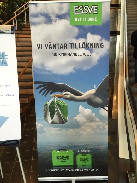 Roll-up banner för byggprodukter med en stork som flyger med en ESSVE-produkt i näbben.