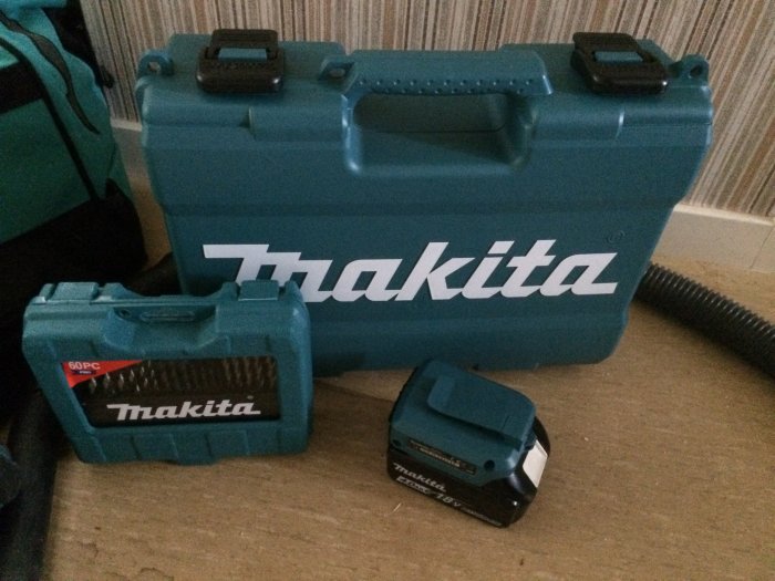 Makita skruvdragarväska och två olika storlekar på batterier med ett mindre USB-adaptertillbehör.