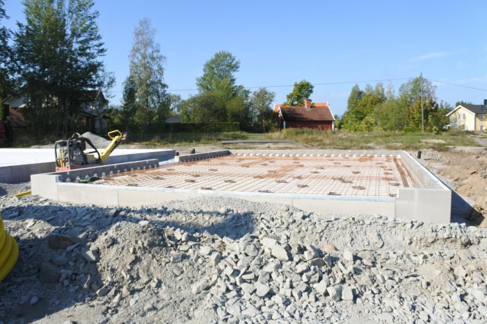 Preparationsnivå för garagegjutning med armering och avloppsrör i cellplast, byggarbetsplats.