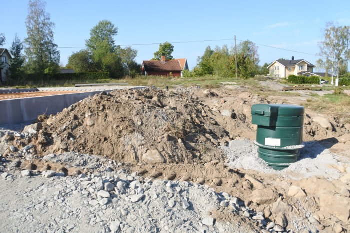 Förberedelse av garagegrund med synligt dräneringsarbete och avloppsrör på byggarbetsplats.