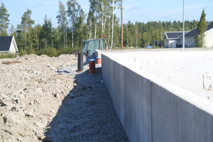 Förberedelse av garagegrund med avloppsrör och cellplast inför gjutning på en tomt.