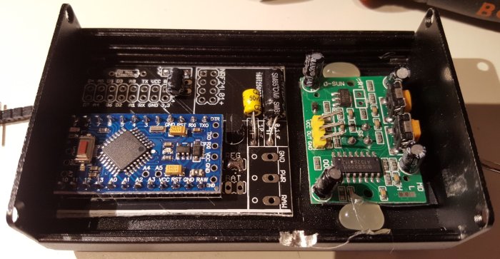 Öppnat aluminiumcase med en elektronisk krets för en NRF24L01+ antennrepeater.