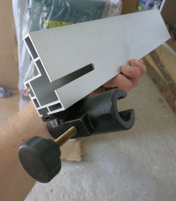 Hand som håller en bandsågens geringsanhåll för kontroll av dess kvalitet.