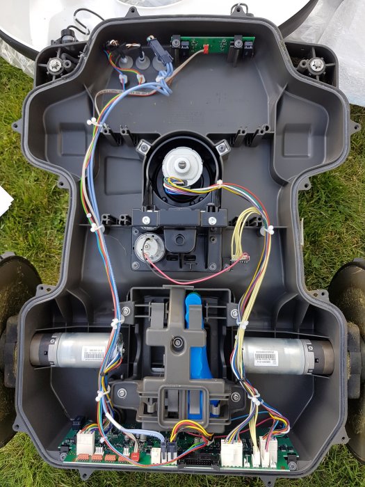 Öppen robotgräsklippare visar interna komponenter, ledningar, och en ledig plats för extra batteri med en märkt kontakt "Batt B".