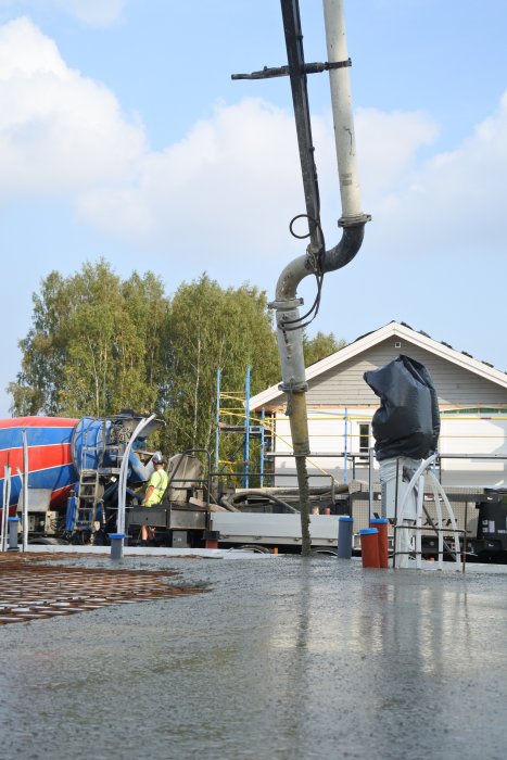 Betong hälls från betongpump in på armerad gjutningsyta på byggplats.